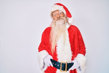 Gri saçlı ve uzun sakallı yaşlı bir adam Noel Baba kostümü giyiyor. Pozitif ve mutlu görünüyor. Kendine güvenen bir gülümsemeyle dişlerini gösteriyor. 