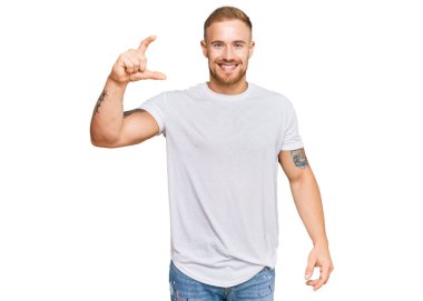 Genç İrlandalı sıradan kıyafetler giyen, gülümseyen, kendine güvenen, el hareketleriyle hareket eden parmaklarıyla işaret eden ve kameraya bakan genç bir adam. ölçüm kavramı. 