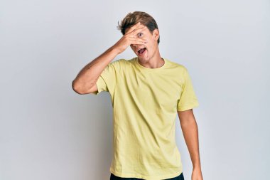 Yakışıklı, beyaz bir adam. Günlük kıyafetler giymiş. Şoka girmiş, yüzünü ve gözlerini kapamış, utanmış ifadesiyle parmaklarından bakıyor.. 