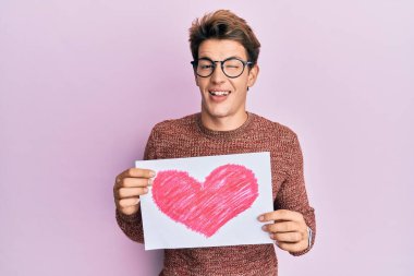 Kalbi olan yakışıklı beyaz adam kameraya seksi bir ifadeyle bakıyor, neşeli ve mutlu bir yüz.. 