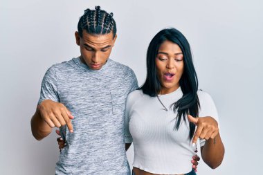 Gündelik giysiler giymiş genç bir çift parmaklarını göstererek reklamını yapıyor, şaşırmış bir yüz ve açık bir ağız. 