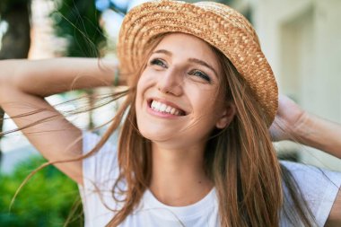 Genç sarışın kadın tatilde gülümsüyor. Mutlu bir şekilde caddede yürüyor.