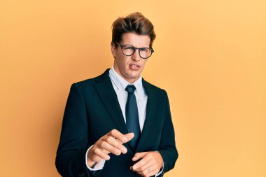 İş elbisesi giyen yakışıklı beyaz adam ve iğrenç bir ifade takınan kravat, tiksinti tepkisi yüzünden tiksindirici ve korkunç bir ifade. Eller havada. 