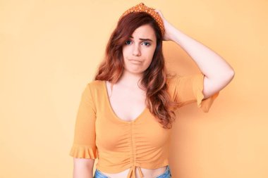 Gündelik giysiler giyen genç ve güzel bir kadın soru sorup kafasını karıştırıyor. Şüpheyle kararsız, kafa kafaya düşünerek. Düşünceli kavram. 