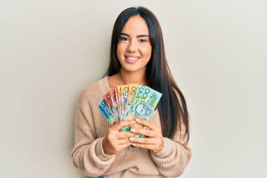 Genç, İspanyol asıllı, elinde dolarlarla gülümseyen mutlu ve havalı bir gülümsemeyle genç bir kız. diş gösterme. 