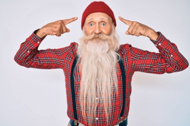 Gri saçlı, uzun sakallı, hippi görünümlü, yün şapkalı, iki eliyle başını gösteren yaşlı bir adam. Harika bir fikir ya da düşünce, iyi bir hafıza. 