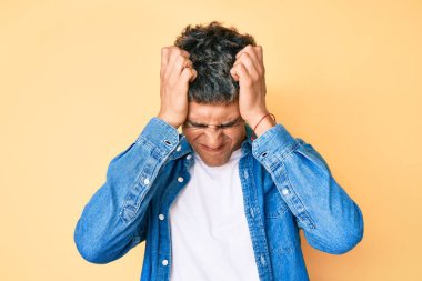 Genç, yakışıklı, gündelik kıyafetler giyen, baş ağrısı çeken çaresiz ve stresli bir adam. Çünkü acı ve migren ağrısı var. Eller başının üstünde.. 