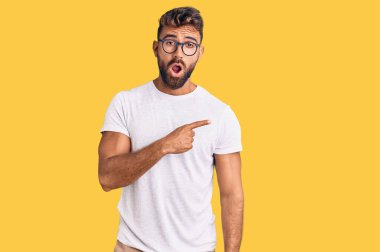 Gündelik kıyafet ve gözlük takan genç İspanyol adam parmaklarını yana çevirerek şaşırdı, ağzı açık hayret içinde kaldı.. 