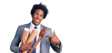 Afro saçlı, elinde kağıt planlar tutan yakışıklı Afro-Amerikalı adam mutlu bir şekilde elini ve parmağını gösterdi. 