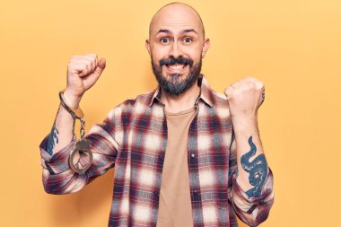 Tutuklu kelepçesi takan yakışıklı genç adam gururla bağırıyor, zaferi kutluyor ve başarıyı kollarını kaldırarak kutluyor. 