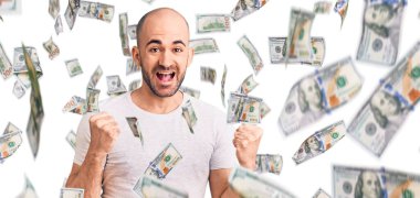 Gündelik tişört giyen genç yakışıklı adam şaşkınlık ve şaşkınlık içinde kollarını kaldırarak ve gözlerini açarak başarıyı kutluyor. Kazanan konsept.