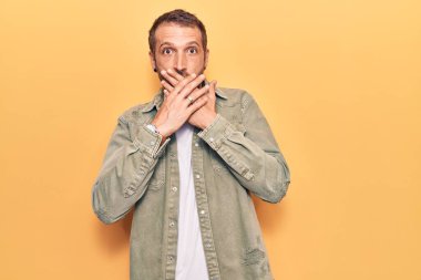 Gündelik giysiler giyen genç yakışıklı adam yanlışlıkla elleri ile ağzını kapatırken şok oldu. gizli kavram. 