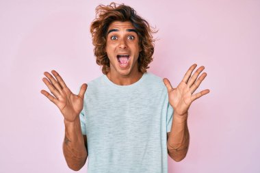 Sıradan kıyafetler giyen genç İspanyol adam çılgın ve başarıyı kollarını kaldırıp heyecanla haykırarak kutluyor. Kazanan konsept 