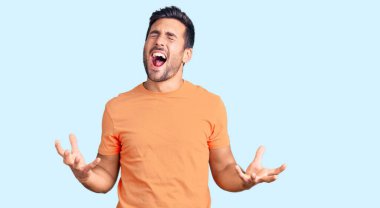 Gündelik kıyafetler giyen genç İspanyol adam deli gibi bağırıyor ve agresif bir ifade ve kollarla bağırıyor. hüsran kavramı. 