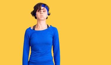 Kısa saçlı, antrenman kıyafetleri giyen, komik yüzlü, yanakları şişen güzel bir genç kadın. Havayla şişmiş ağız, çılgın bir ifade.. 