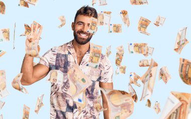 İspanyol asıllı genç adam dört numarayı gösterip gösterirken kendinden emin ve mutlu bir şekilde gülümsüyor..