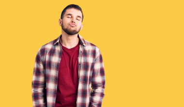 Genç ve yakışıklı bir adam, sıradan bir gömlek giyip kameraya bakıyor ve güzel ve seksi bir şekilde havadan öpücük yolluyor. aşk ifadesi. 