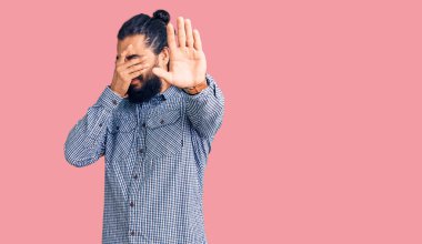 Genç Arap adam gündelik giysiler giyip elleri ile gözleri kapatıyor ve üzgün ve korku ifadeleriyle jest yapıyor. utangaç ve olumsuz kavram. 