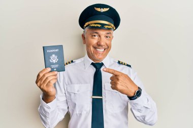 Yakışıklı, orta yaşlı, olgun bir pilot, elinde pasaportuyla gülümsüyor. 