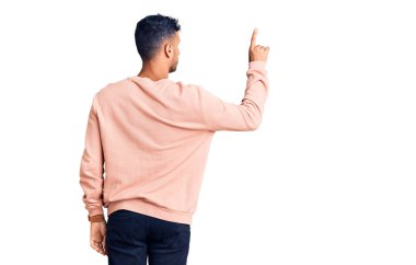 Latin asıllı genç adam gündelik giysiler giyip geriye doğru poz veriyor. 