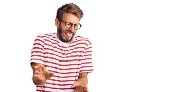 Sakallı, sıradan kıyafetler ve gözlük takan yakışıklı sarışın adam tiksindirici ve tiksindirici bir ifade takınıyor çünkü tiksindirici bir tepki veriyor.. 