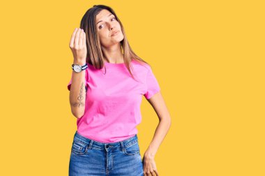 Güzel beyaz kadın gündelik kıyafetler giyip İtalyan jesti yapıyor. Elleri ve parmakları kendinden emin bir ifadeyle. 