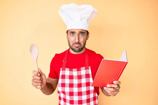 Jonge Latijns Amerikaanse Man Draagt Professionele Bakker Schort Lezen Kookboek — Stockfoto