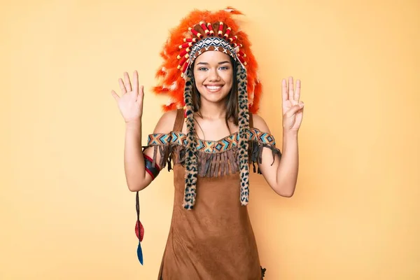 若いです美しいですラテン女の子身に着けていますインディアン衣装ショーとポイントアップとともに指番号8ながら笑顔自信と幸せ — ストック写真