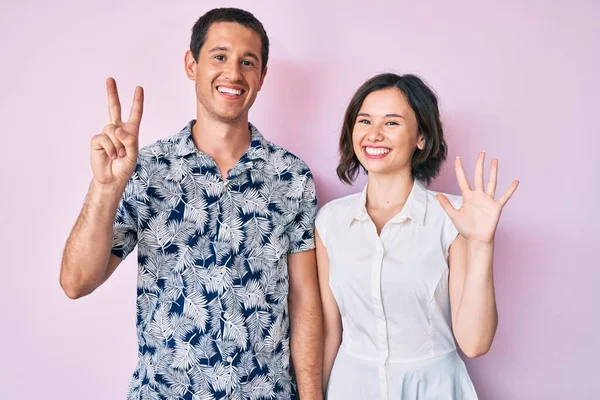 Schönes Paar Lässiger Kleidung Zeigt Mit Finger Nummer Sieben Nach — Stockfoto