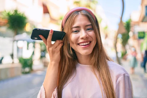 Jovem Caucasiana Sorrindo Feliz Ouvir Mensagem Áudio Usando Smartphone Cidade — Fotografia de Stock