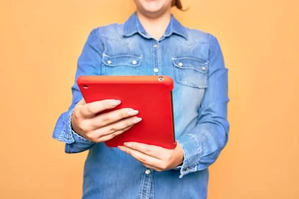 Sarı Arka Planda Duran Tablet Kullanan Beyaz Bir Kadın — Stok fotoğraf