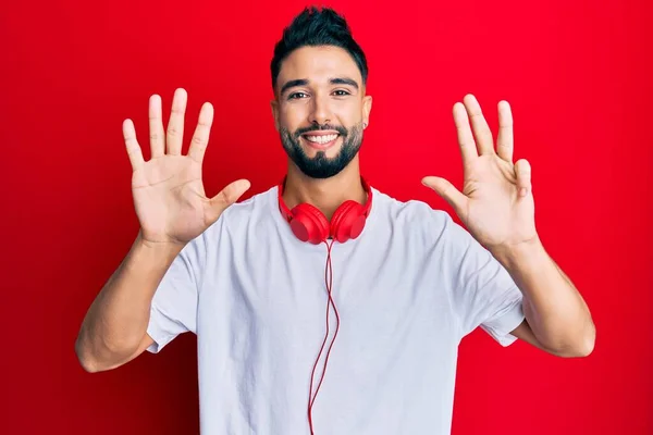 Jovem Com Barba Ouvindo Música Usando Fones Ouvido Mostrando Apontando — Fotografia de Stock