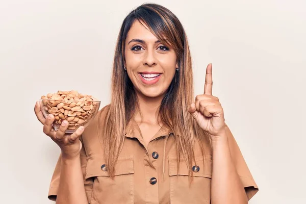 Young Beautiful Woman Holding Bowl Peanuts Smiling Idea Question Pointing — Stock Photo, Image