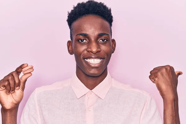 Jeune Homme Afro Américain Tenant Macaron Pointant Pouce Vers Côté — Photo