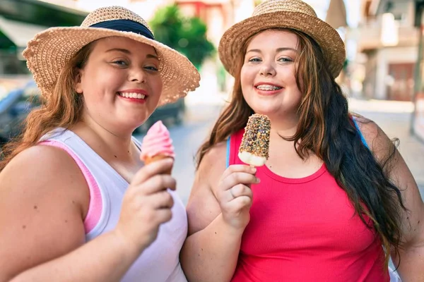 二つのプラスサイズ太りすぎ姉妹双子女性笑顔食べますAアイスクリーム屋外 — ストック写真