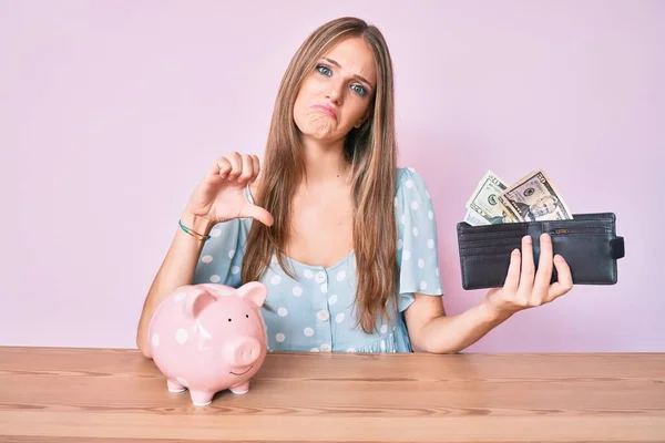 Jong Blond Meisje Met Portemonnee Met Dollars Spaarvarken Zittend Tafel — Stockfoto