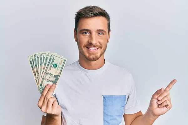 Hombre Caucásico Guapo Sosteniendo Billete Dólares Sonriendo Feliz Señalando Con —  Fotos de Stock