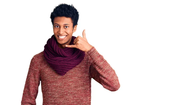 カジュアルな冬のセーターを着た若いアフリカ系アメリカ人の男性とスカーフは 電話で話すような手と指で電話のジェスチャーをして笑っています コミュニケーションの概念 — ストック写真