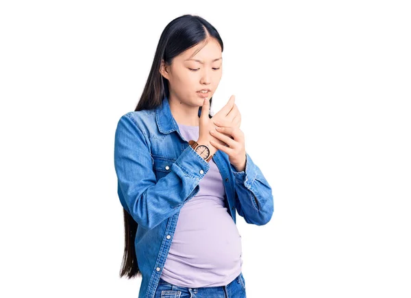 若い美しい中国の女性妊娠中の赤ちゃんの痛みを期待する手と指 関節炎の炎症 — ストック写真
