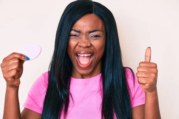 Mujer Afroamericana Joven Sosteniendo Esponja Maquillaje Gritando Orgulloso Celebrando Victoria —  Fotos de Stock