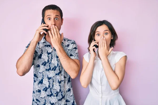 Vackra Par Som Pratar Smartphone Täcker Munnen Med Handen Chockad — Stockfoto