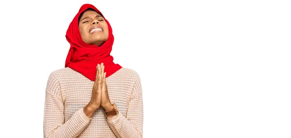 伝統的なイスラムのヒジャーブスカーフを身に着けている若いアフリカ系アメリカ人女性は 非常に感情的で心配している顔に希望の表現と一緒に手で物乞いと祈ります お願い — ストック写真
