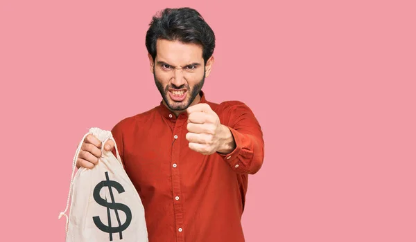 Young Hispanic Man Holding Dollars Bag Annoyed Frustrated Shouting Anger — Stock Photo, Image