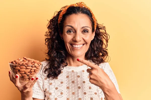 Mulher Meia Idade Bonita Segurando Tigela Com Amêndoas Sorrindo Feliz — Fotografia de Stock