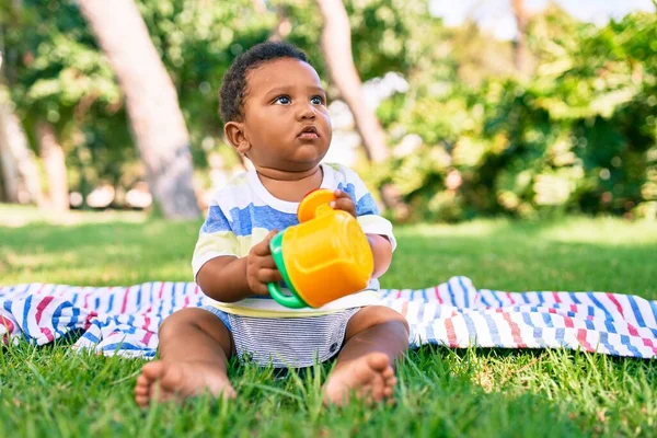 可爱的非洲裔美国胖乎乎的小孩坐在公园的草地上玩玩具 — 图库照片