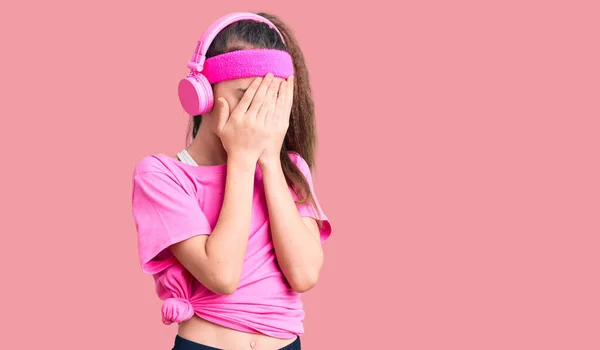 Χαριτωμένο Ισπανόφωνο Κορίτσι Φορώντας Ρούχα Γυμναστικής Και Χρησιμοποιώντας Ακουστικά Λυπητερή — Φωτογραφία Αρχείου