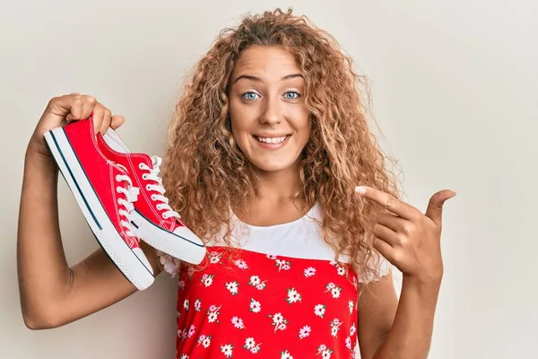 Hermosa Chica Adolescente Caucásica Sosteniendo Zapatos Casuales Rojos Sonriendo Feliz —  Fotos de Stock
