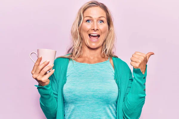 Middle Age Caucasian Blonde Woman Drinking Cup Coffee Pointing Thumb — Stock Photo, Image