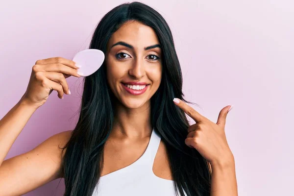 Vacker Latinamerikansk Kvinna Håller Makeup Svamp Ler Glad Pekar Med — Stockfoto