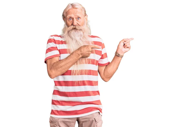 年长的老人 白发苍苍 长胡子 穿着条纹T恤 双手都指向一边 忧心忡忡 满脸诧异 — 图库照片